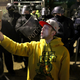 A protester takes a selfie in front of police dispersing the Capitol riot.